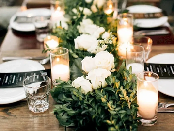 Elegant table setting with white roses and candles.