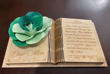 Wooden book with engraved poem and green paper flower, dedicated to Mom.