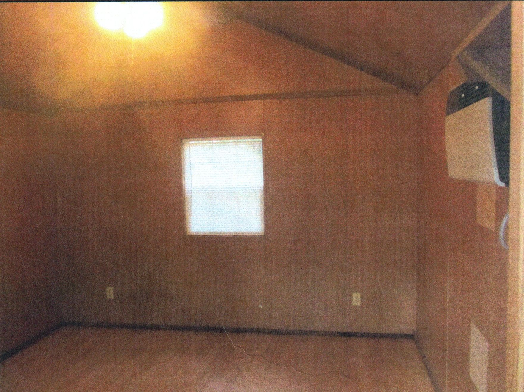 Inside of a cozy cabin rental at Hanna Park showing the floor and a window