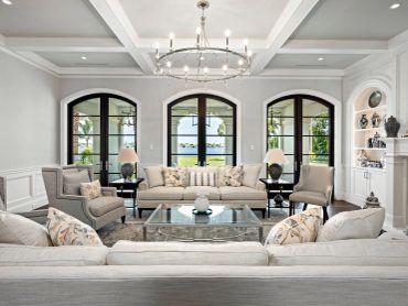Elegant living room with neutral tones and large arched windows.