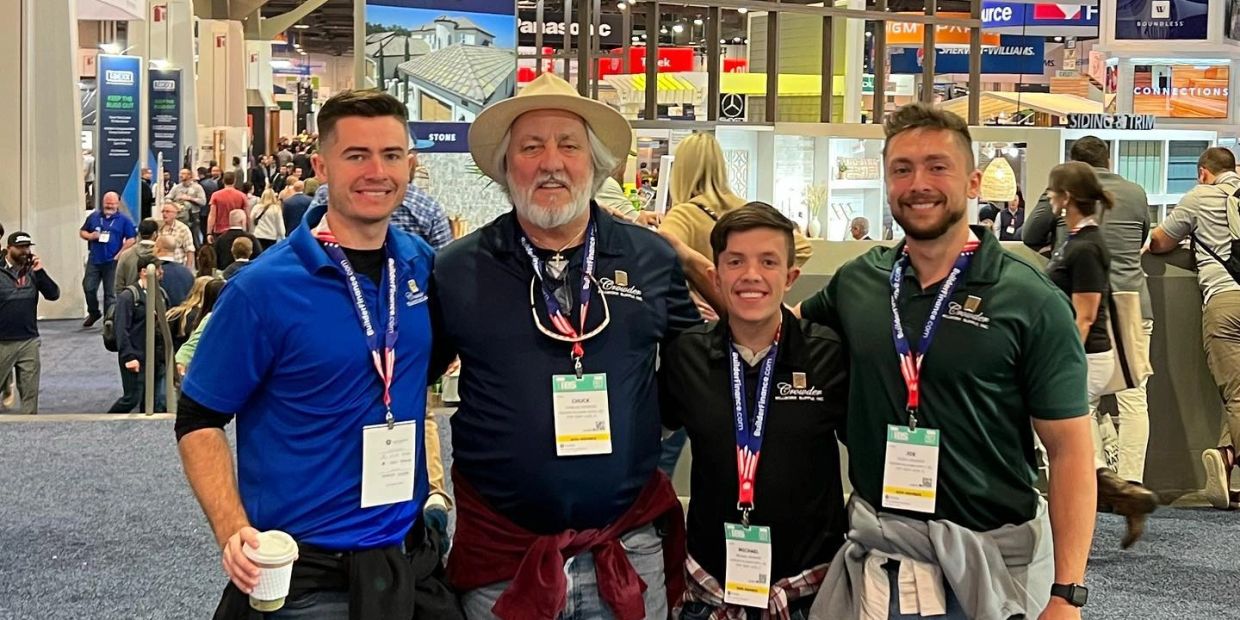 Four men posing together at a convention.