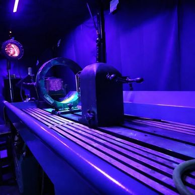A scientific apparatus with glowing blue and purple lighting in a dark room.