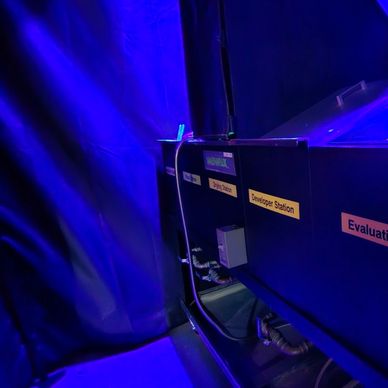 Dark room with a labeled device under blue lighting.
