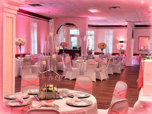 Elegant banquet hall decorated with pink and white for a special event.