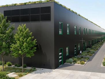 Modernes Industriegebäude mit Dachbegrünung und Bäumen.