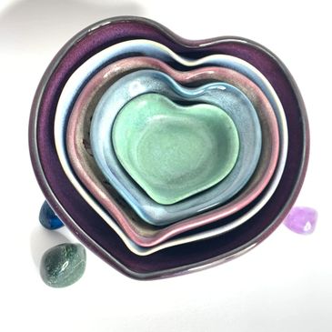 Ceramic heart-shaped bowls stacked, with crystals nearby.