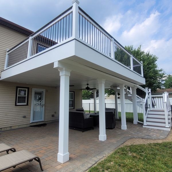 Second story waterproof deck, with underside paver patio, and fenced in dog area on the right side o