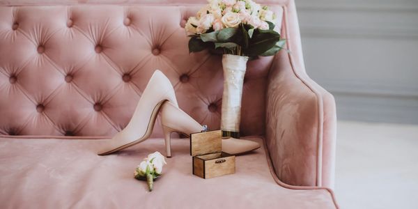 Elegant wedding accessories on a pink velvet sofa.