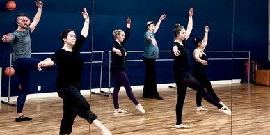 Group dance class practicing ballet moves.