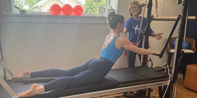 Woman doing pilates with instructor guidance.