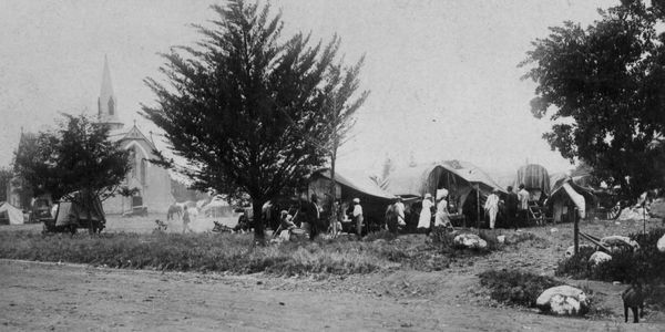Early 20th-century Naachtmaal Church Square with tents and people gathered.