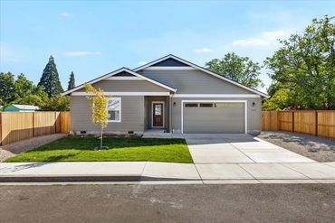 Modern single-story house with a two-car garage and a small front yard.