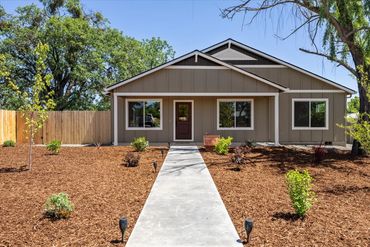 A single-story house with a clean landscaped front yard and a concrete path.