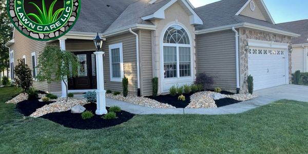 Well-maintained suburban house with fresh landscaping and a green lawn.