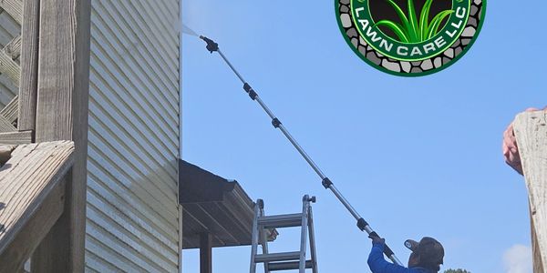 Worker pressure washing house siding with long wand, K&G Lawn Care logo.