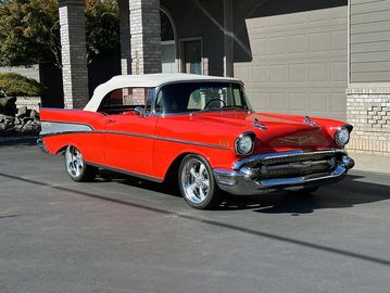 Classic red convertible car parked outside.