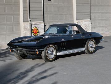 Classic black Corvette Stingray convertible parked outdoors.