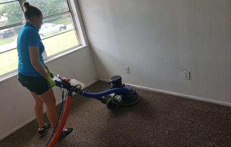 Woman cleaning carpet with machine.