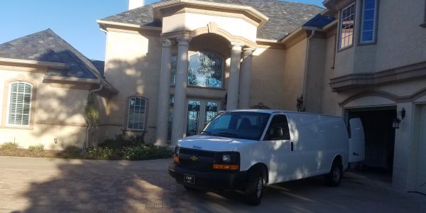 White van parked outside a large house.