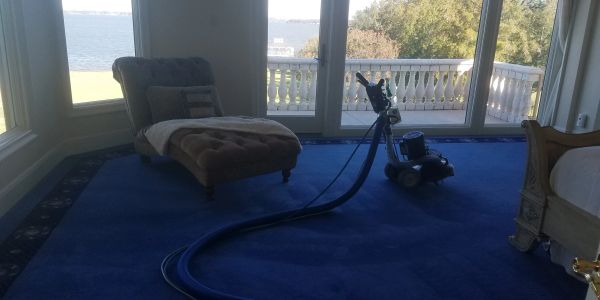 Room with blue carpet and cleaning machine.