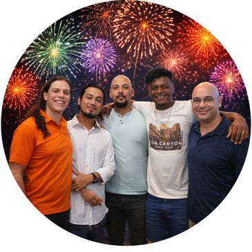 Five men smiling together with fireworks in the background.