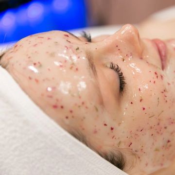 Person with a facial mask on, eyes closed, relaxing.