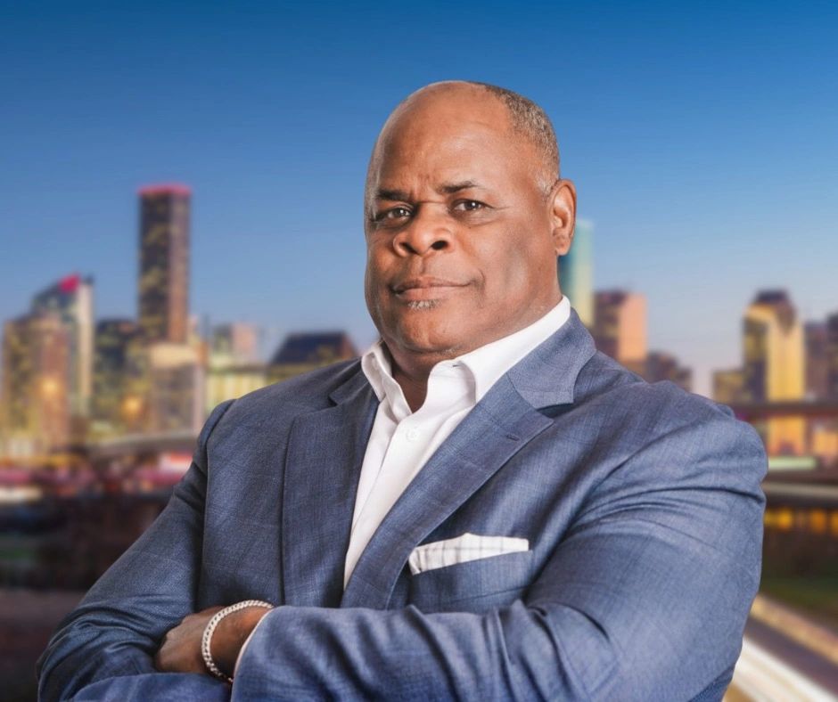 Professional portrait of real estate agent Michael Jones with the Houston skyline in the background.