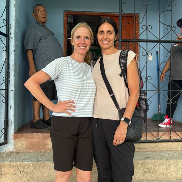 Two women smiling and posing together outdoors.