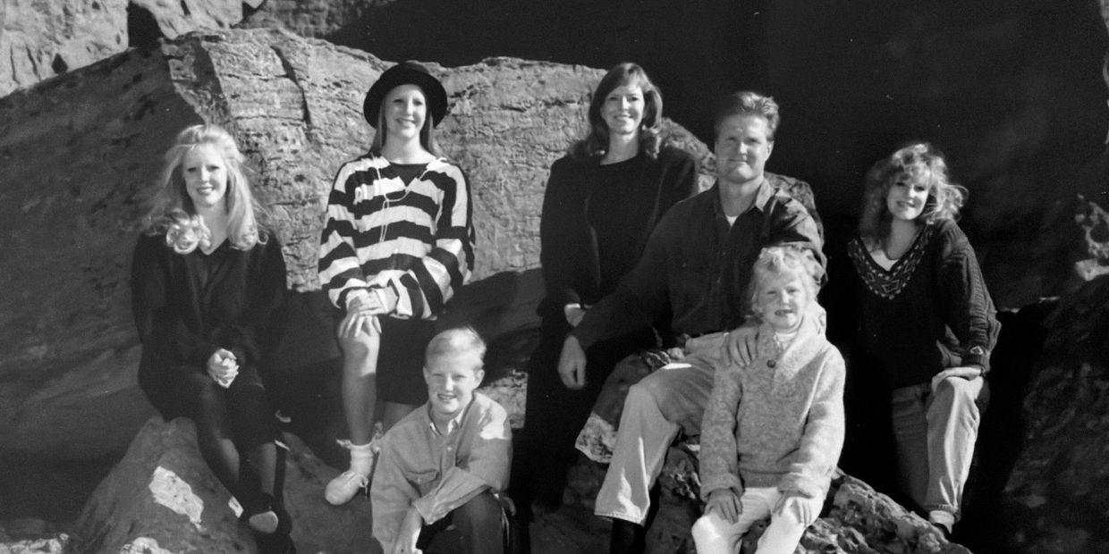 A black-and-white photo of seven people posing on rocks outdoors.
