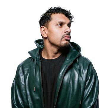 Man wearing a dark green leather jacket looking sideways.