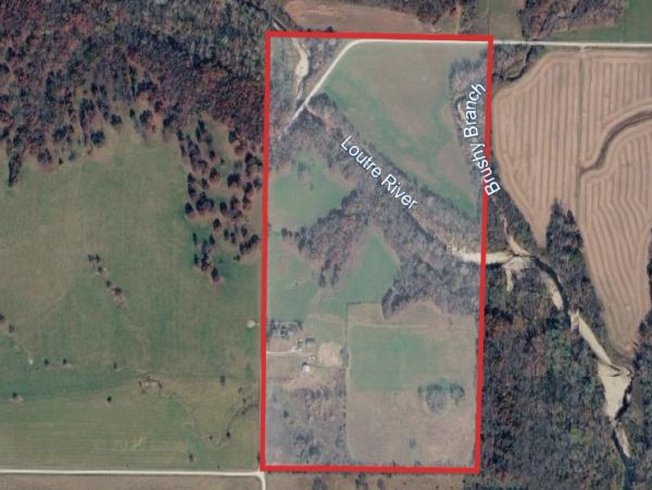Aerial view of rural land with rivers and fields marked by a red boundary.