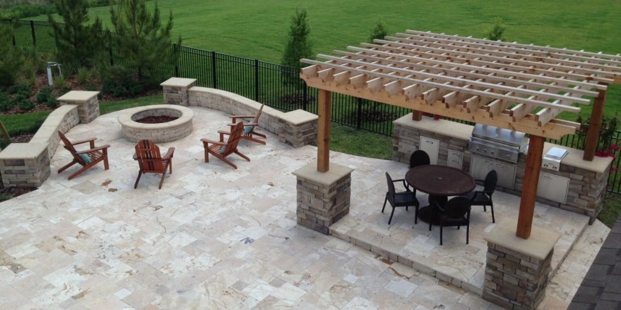 Spacious backyard patio with fire pit, wooden pergola, and outdoor kitchen area.