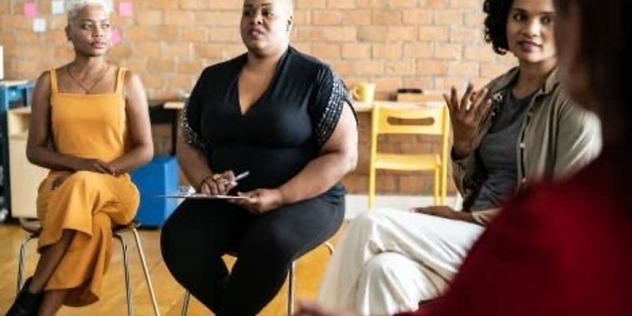 Four women engaged in a group discussion in a casual setting.