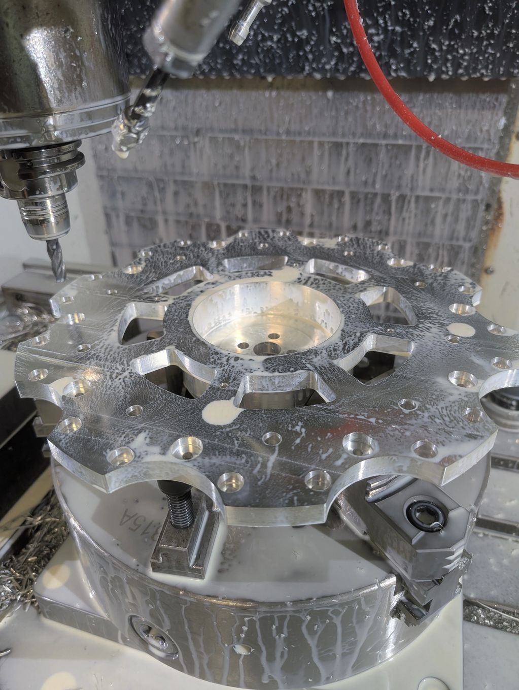 Machining a metal gear part with coolant flow.
