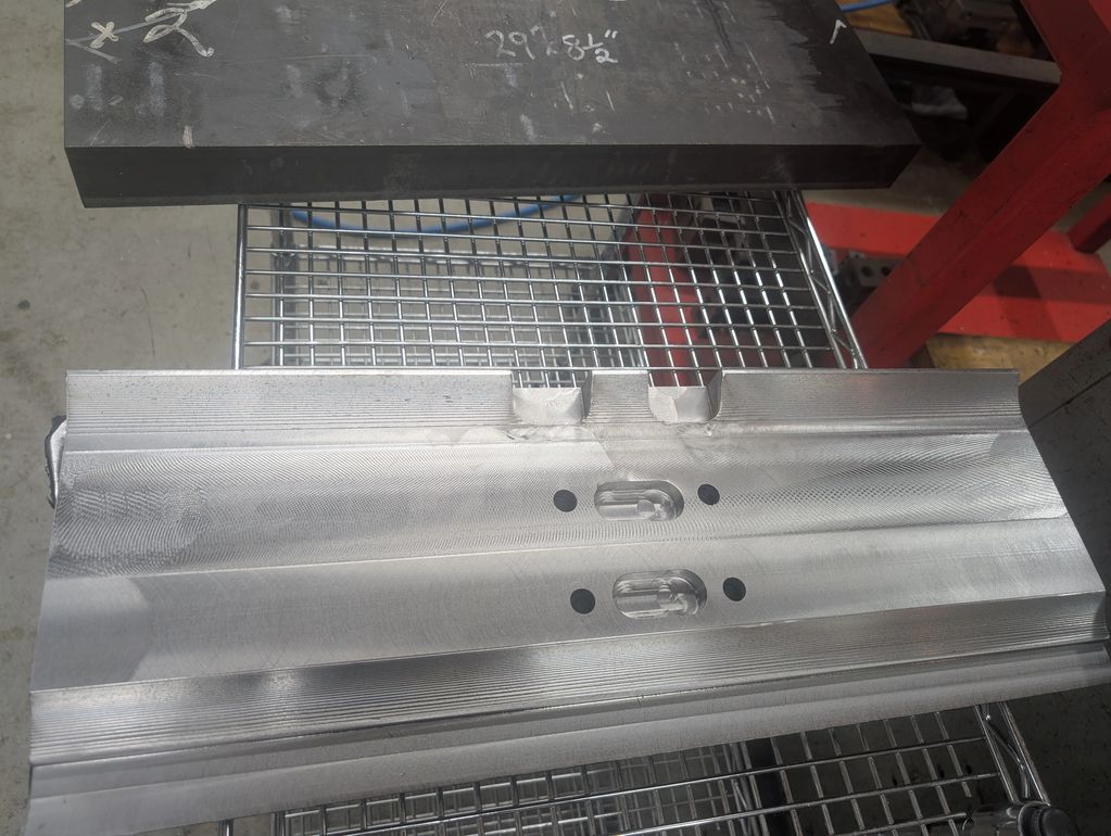 Machined metal part with grooves and holes.