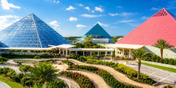 Three colorful glass pyramids under a bright blue sky.