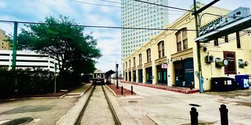 A streetcar on tracks near historic buildings in an urban setting.