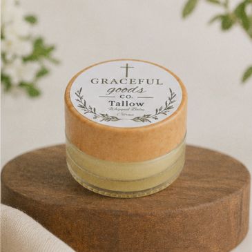 Jar of Graceful Goods Co Tallow balm on a wooden surface.