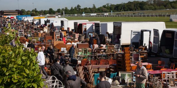 Outdoor market with furniture and antiques on display.