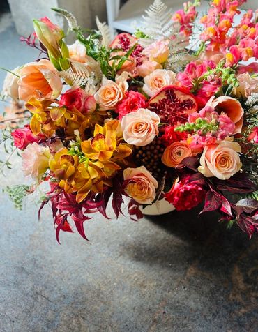 A vibrant bouquet of mixed flowers with roses and orchids.