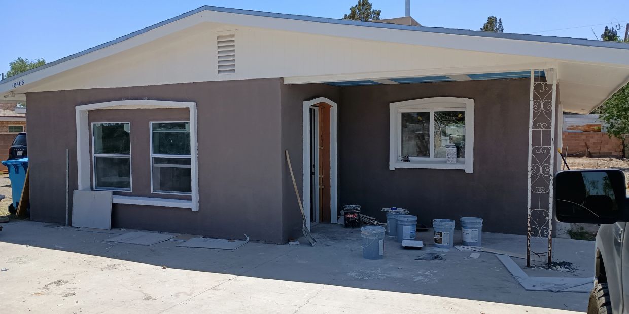 Small house exterior with painting supplies outside.