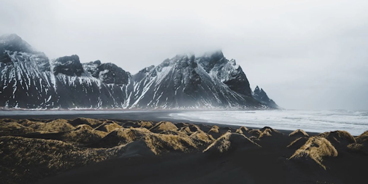 Black sand beach and snowy mountain