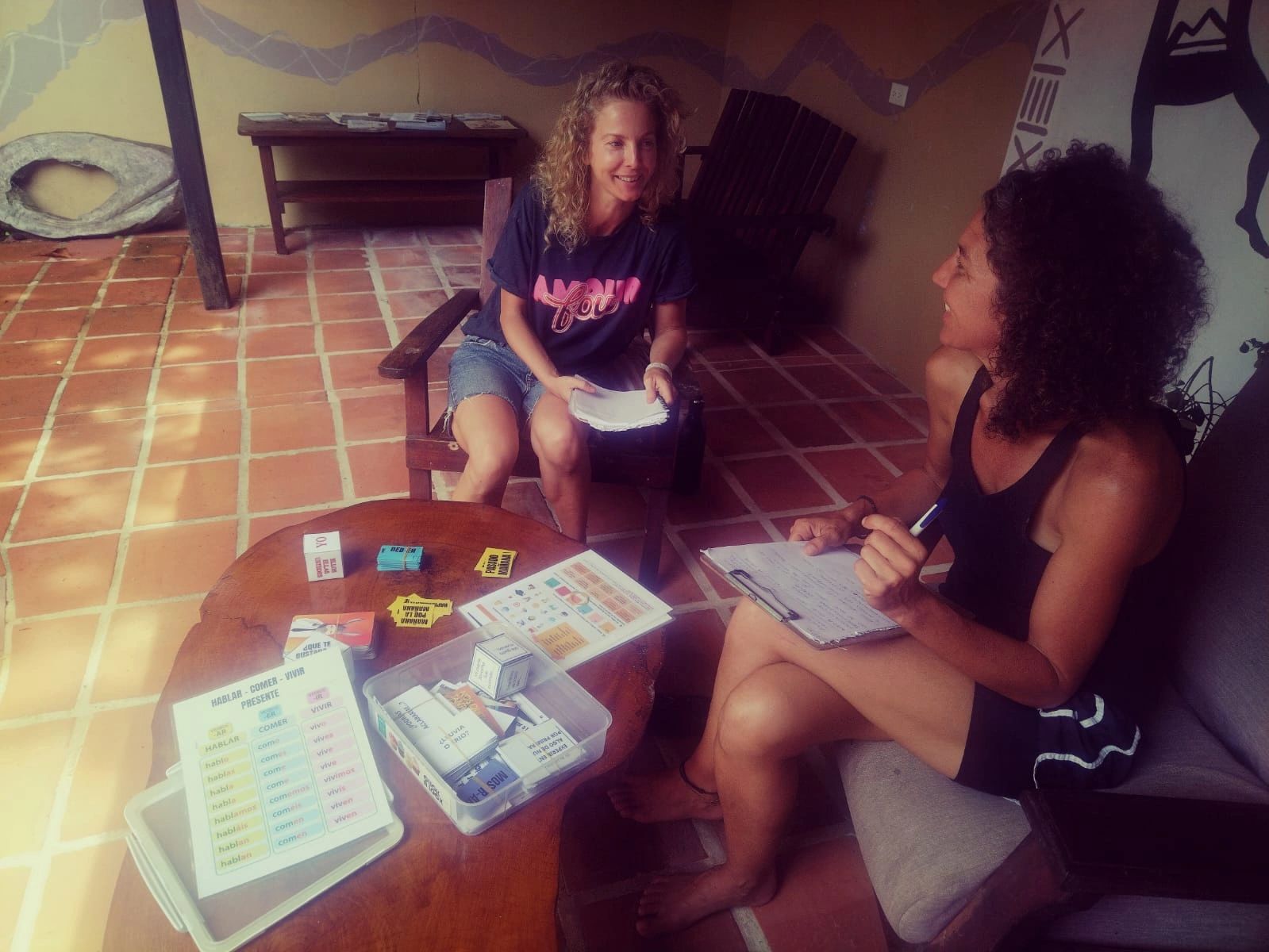 Two women studying with notebooks and learning materials.