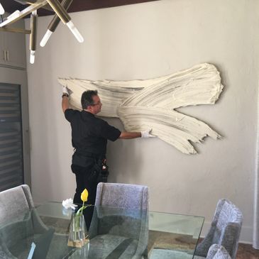 Greg Ripley installing a piece by Donald Martiny with Dimmitt Contemporary Art. 
