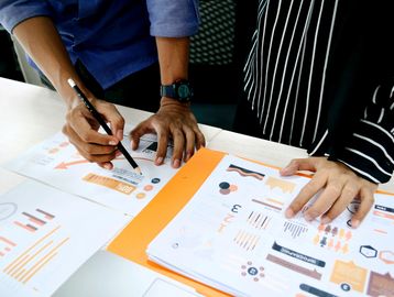 Two people reviewing graphs, charts and data at Strategic Data Consultancy
