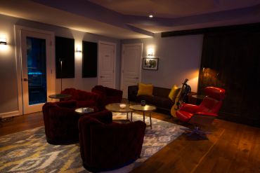 Cozy living room with modern lighting and red chairs.