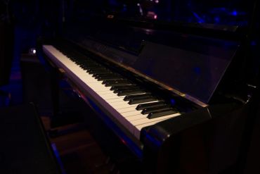Close-up of piano keys in a dimly lit room.
