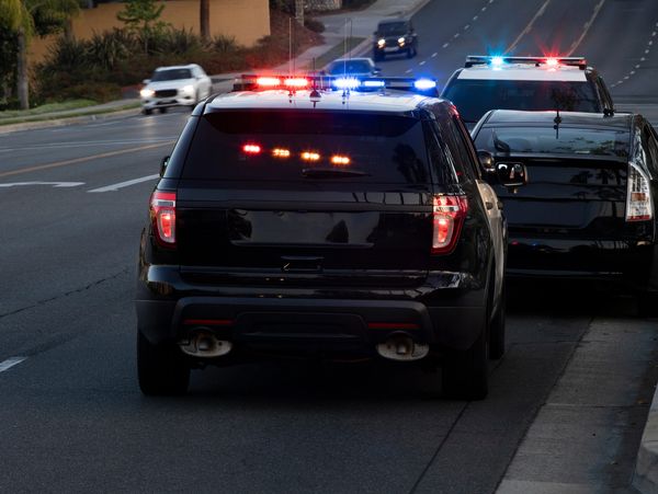 Two police vehicles with flashing lights on a street.