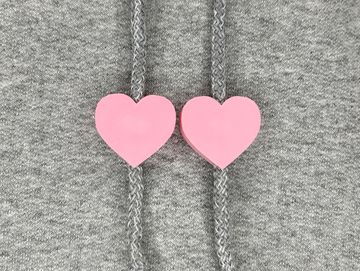 Pink heart charms on sweatshirt drawstring.
