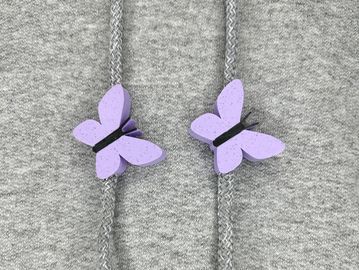 Light purple butterfly sweatshirt charms on a grey sweatshirt